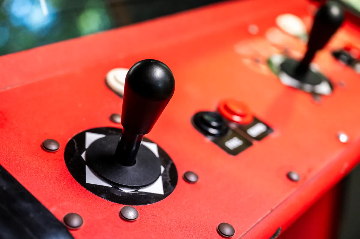 This energetic image features a classic arcade game machine with colorful buttons and a vibrant red cabinet, inviting guests to relive nostalgic gaming moments. The setup is perfect for group play, high-score challenges, and shared laughter.