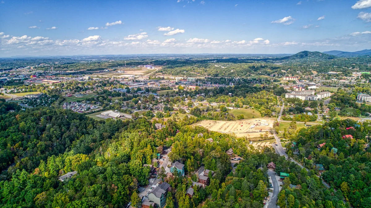 This view image captures rolling hills, a dense forest, scattered homes, and open fields under a wide sky. It evokes a sense of adventure and exploration, connecting the property to its beautifully scenic surroundings—the very landscape guests can explore during their stay.